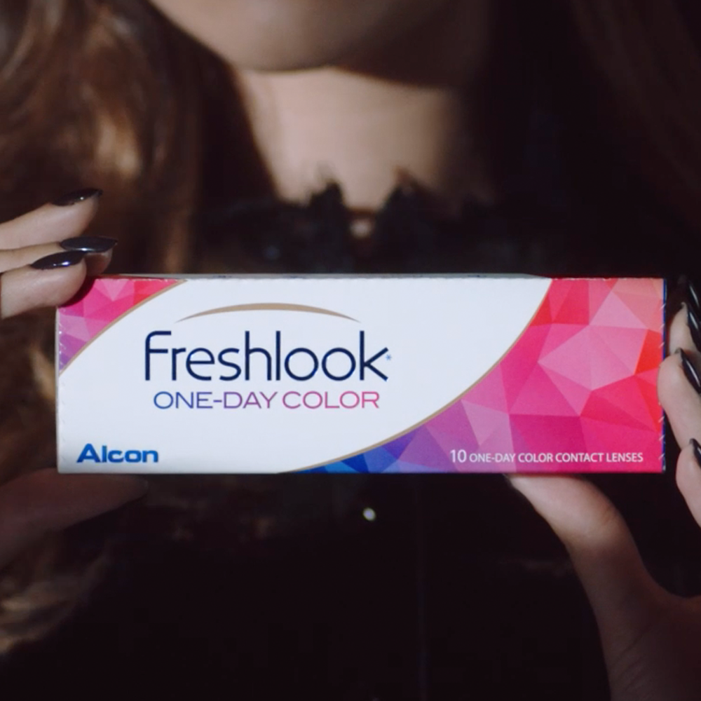 Woman holding a box of Freshlook One-Day Color contact lenses