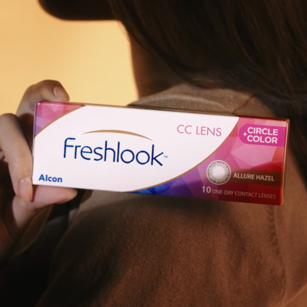 Woman's hand holding a box of Freshlook Circle + Color contact lenses